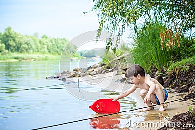 Baby boy playing with ship toy at sea. Child os on vacation in summer at the beach on vacations Stock Photo