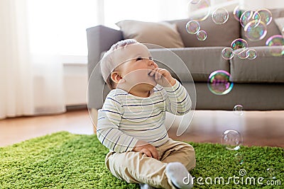 Baby boy playing with soap bubbles at home Stock Photo