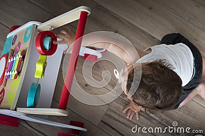 Baby boy playing with walking toy. Top view, indoor Stock Photo