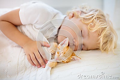 Baby boy sleeping with kitten. Child and cat Stock Photo