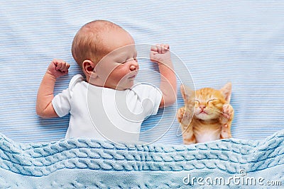 Baby boy sleeping with kitten. Child and cat Stock Photo