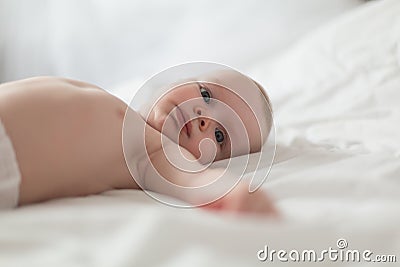 Baby boy in white sunny bedroom Stock Photo