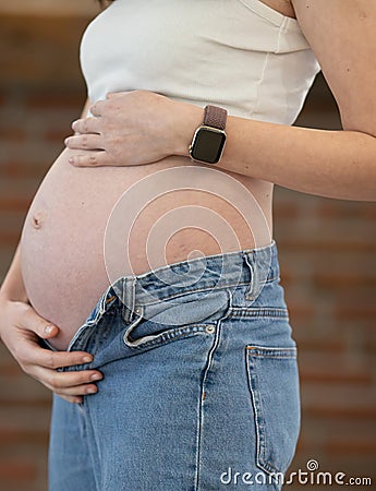 Baby bump in 6-th month with hands. Stock Photo