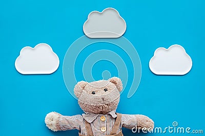 Baby care. Newborn baby concept. Baby sleep concept. Teddy bear toy near clouds on blue background top view Stock Photo