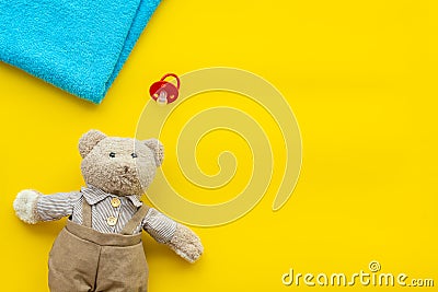 Baby care. Newborn baby concept. Teddy bear toy near pacifier on yellow background top view space for text Stock Photo