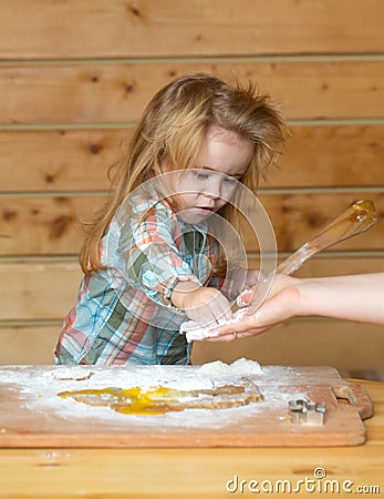 Baby child cooking, playing with flour at wooden kitchen. Stock Photo