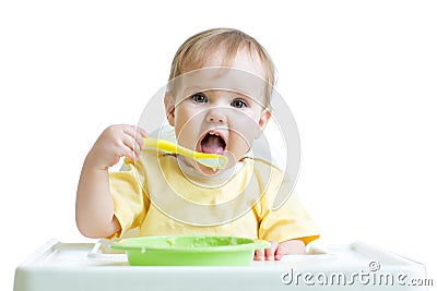 Baby child eating healthy food with a spoon Stock Photo