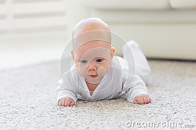 Baby, childhood, people concept - Portrait of a crawling baby on the floor Stock Photo