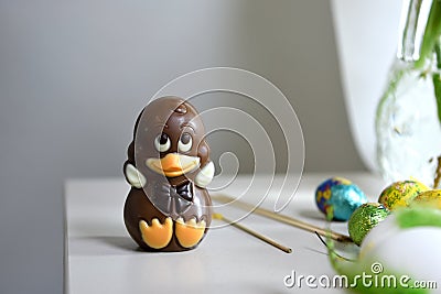 A baby chocolate duck on a table with some Easter eggs Stock Photo