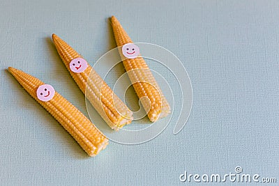 Baby corn with funny faces. Healthy organic food Stock Photo