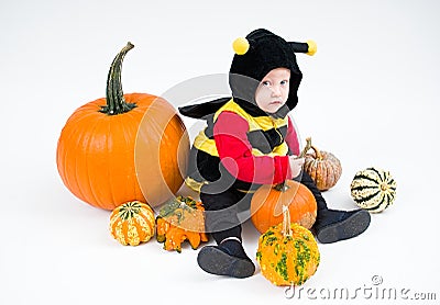 Baby in costume with pumpkins on white background Stock Photo