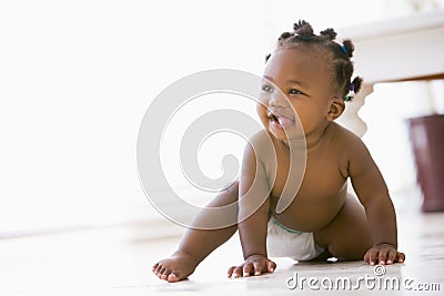 Baby crawling indoors smiling Stock Photo