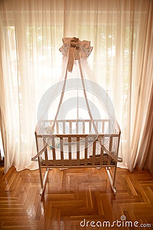 Baby crib by the window on a bright sunny day Stock Photo