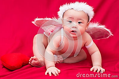 Baby cupid on red background Stock Photo