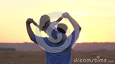 Baby and daddy dream of becoming a pilot. child sits on father`s neck waving his arms together, flies like an airplane Stock Photo