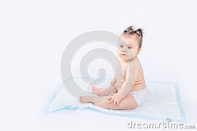 Baby in diapers sitting on a disposable diaper on a white insulated background, space for text, baby hygiene Stock Photo