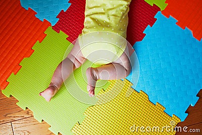 Baby doing tummy time on colorful play mat Stock Photo