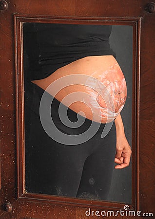 Baby drawn on belly of pregnant woman in mirror Stock Photo