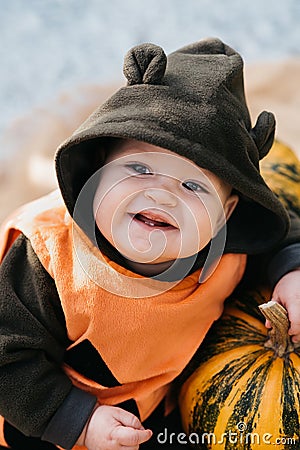 Baby Dressed as Pumpkin with Halloween Pumpkins Stock Photo