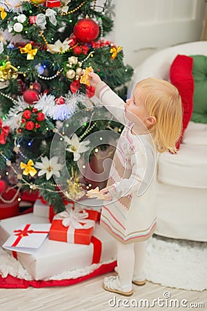 Baby eating cookies near Christmas tree Stock Photo