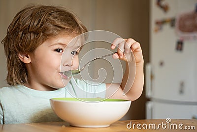 Baby eating food on kitchen. Happy child. Cute kid are eating. Little baby are eating. Little boy having breakfast in Stock Photo