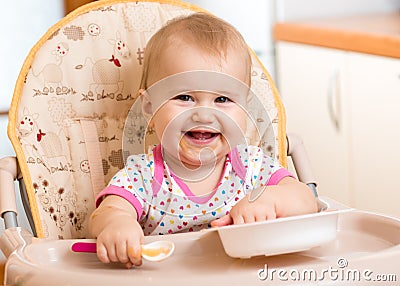 Baby eating food on kitchen Stock Photo