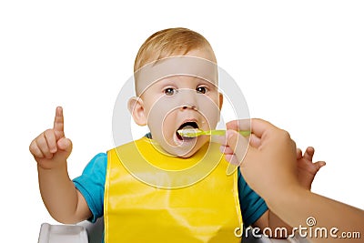 Baby eating spoon baby food jar. Child feeding. Stock Photo