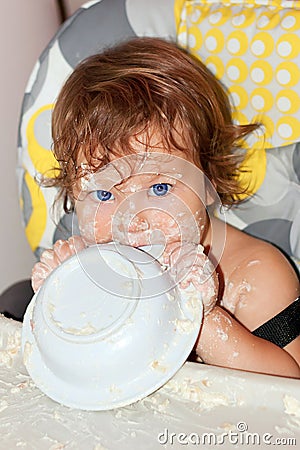 Baby eating yogurt and soiled face Stock Photo