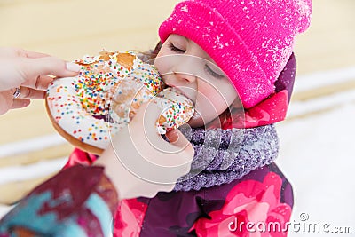 Baby eats bagel in park Stock Photo
