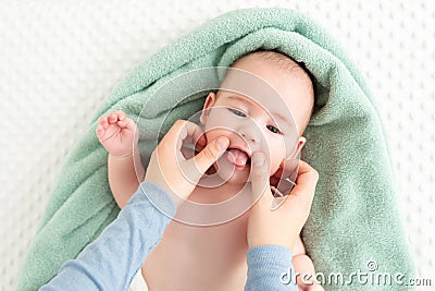 Baby face massage background. Mother gently stroking baby boy face with both hands. Close up cropped shot. Stock Photo