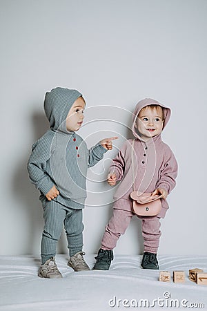 Baby fashion. Unisex gender neutral clothes for babies. Two Cute baby girls or boys in cotton set Stock Photo