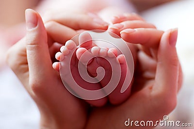 Baby feet cupped into mothers hands Stock Photo