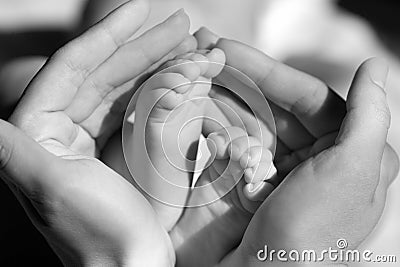 Baby feet cupped into mothers hands Stock Photo