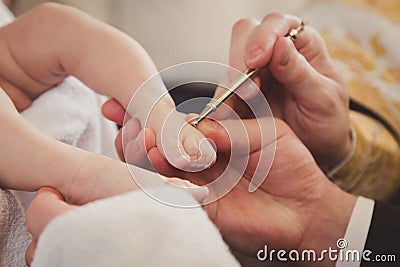 Baby feet in Daddy`s hand. Christening. Stock Photo