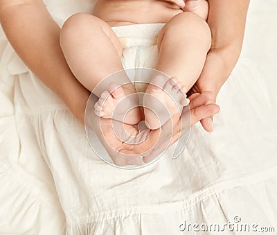 Baby feet in mother hand, health care concept, body and skin, yellow toned Stock Photo