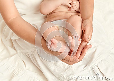 Baby feet in mother hand, health care concept, body and skin, yellow toned Stock Photo