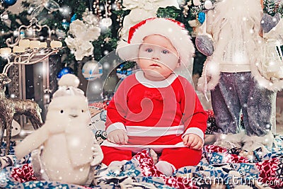 Baby first Christmas. New Year holidays. Baby with santa hat with gift. Stock Photo