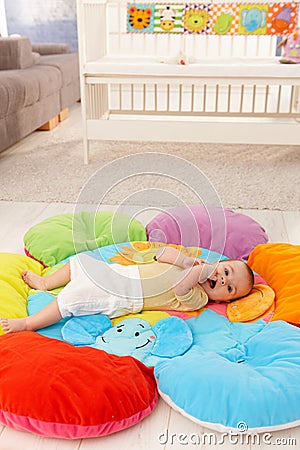 Baby on flowery playmat Stock Photo