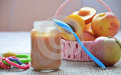 Baby food, baby fruit mashed in a glass jar, peach, beautiful peaches in a basket, children`s toy. apple Stock Photo