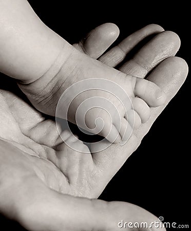 Baby foot on mans hand in black and white Stock Photo
