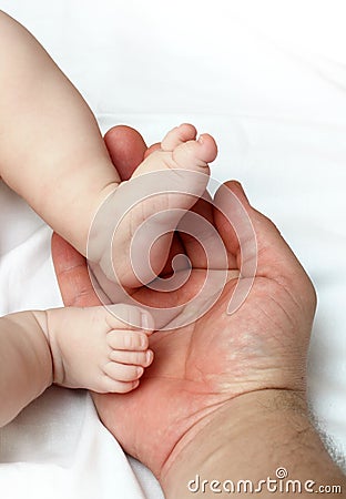 Baby foots on father palm Stock Photo