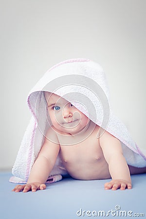 Baby girl after bath with a towel on her head in consideration. Stock Photo