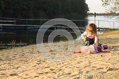 Baby girl beach playing alone sand spring clothes Stock Photo