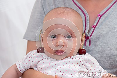 Baby girl with cherries on the ears Stock Photo