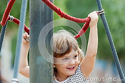 Baby girl climbing at ropes Stock Photo