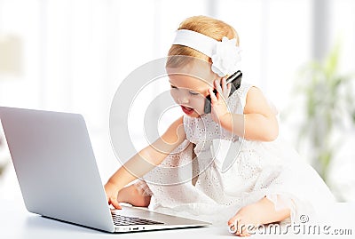 Baby girl with computer laptop, mobile phone Stock Photo