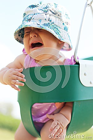 Baby Girl Crying in Toddler Swing Stock Photo