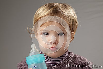 Baby girl drinking her milk in a baby bottle Stock Photo