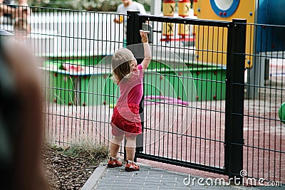 Baby girl go to the child playground, open the door Stock Photo