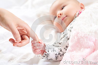 Baby girl grasping her parents finger Stock Photo